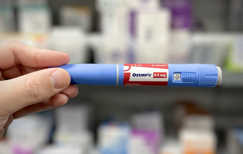 Ozempic Weight Loss Plateau: Why It Happens & Exactly How to Pharmacist Holding Ozempic Weight Loss Pen