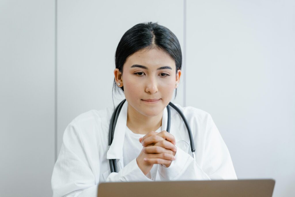 What to Eat the First Week on Ozempic (and What to Avoid) Young female doctor in white coat consulting online with stethoscope indoors.